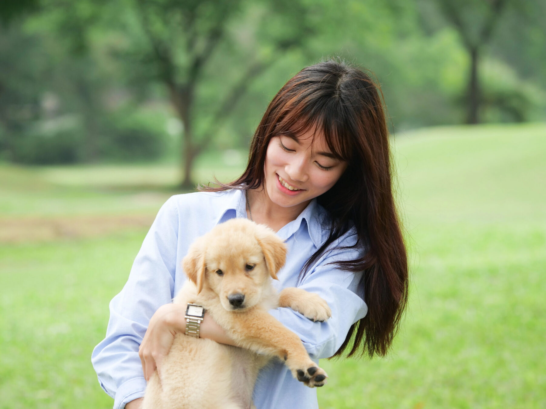smiling young woman holding a puppy